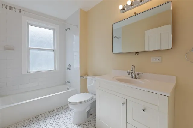 a bathroom with a toilet a sink a mirror and bathtub