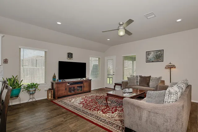 a bedroom with a bed a table and windows