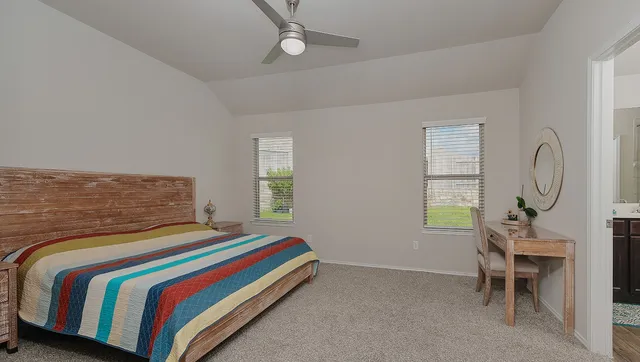 a spacious bedroom with a bed and wooden floor