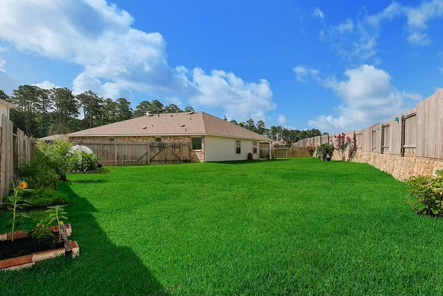 a view of a big room with of big yard and large trees