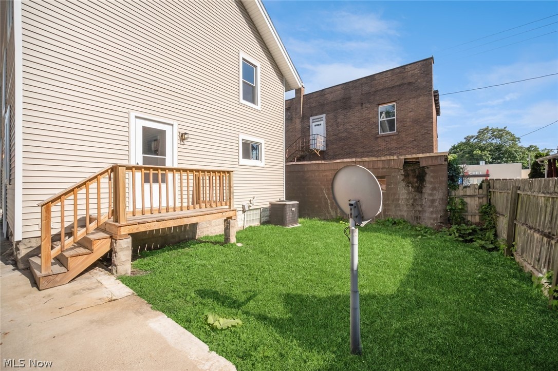 809 Wales Road Northeast Massillon, OH 44646 - Photo 15 of 15 View of yard featuring central AC and a wooden deck