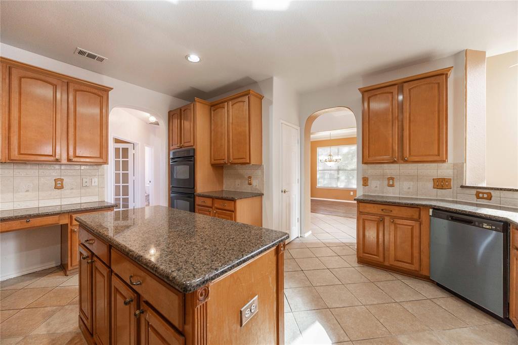 9201 Hunter Chase Drive McKinney, TX 75072 - Photo 11 of 35 a kitchen with stainless steel appliances granite countertop a sink counter space cabinets and a window