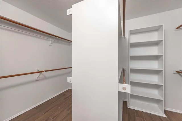 a view of walk in closet with empty racks