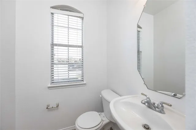 a bathroom with a sink mirror and toilet