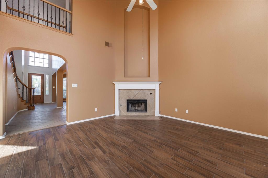 9201 Hunter Chase Drive McKinney, TX 75072 - Photo 5 of 35 a view of an empty room with wooden floor and a fireplace