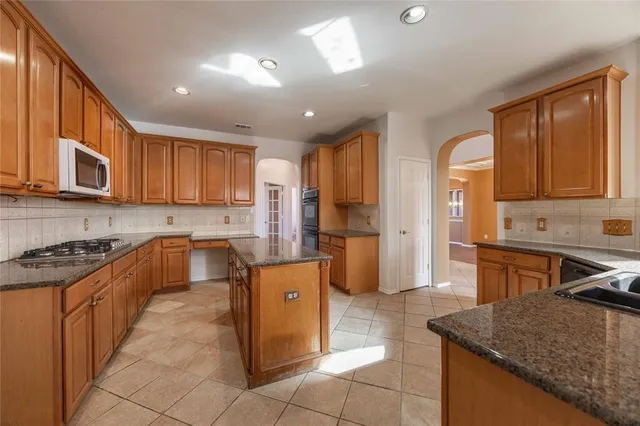 a kitchen with stainless steel appliances granite countertop a stove sink and cabinets