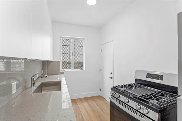 a kitchen with granite countertop a stove and a sink