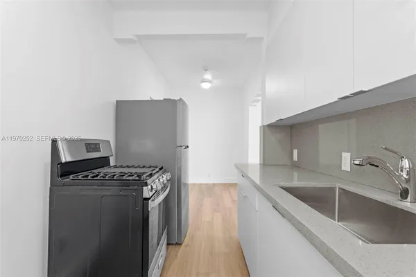 a kitchen with stainless steel appliances a sink a stove and a refrigerator