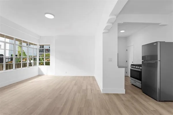 a view of a kitchen with a stove fridge and wooden floor