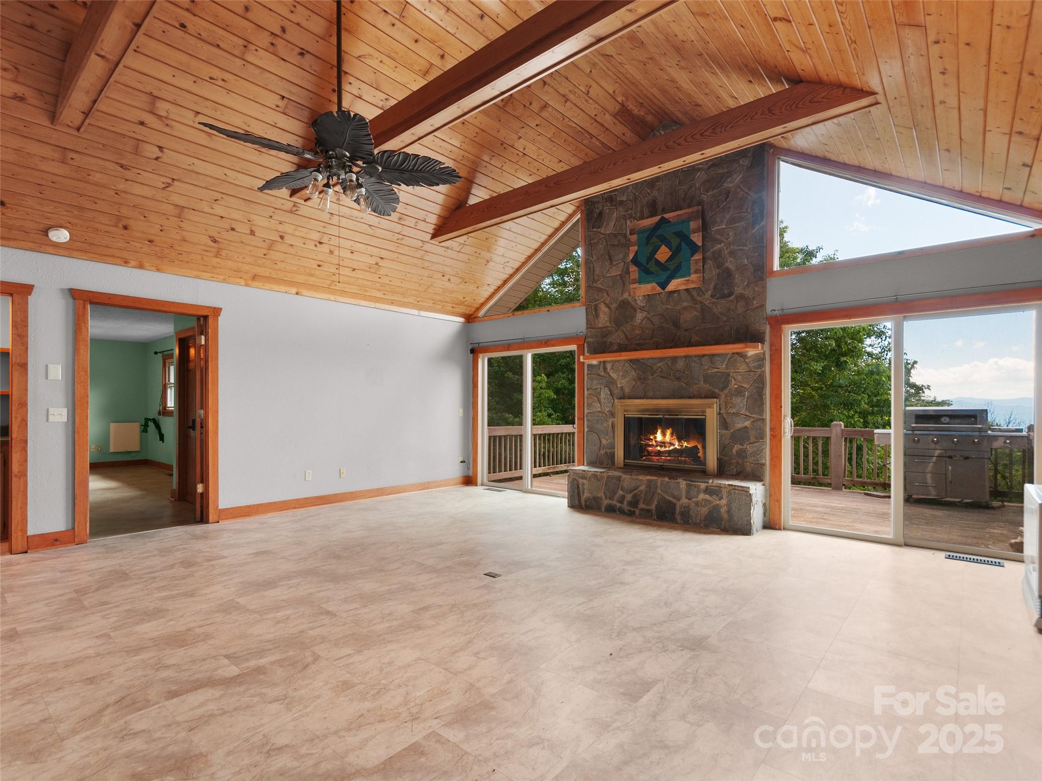 672 Windswept Ridge Road Leicester, NC 28748 - Photo 10 of 30 a view of a livingroom with a fireplace and a ceiling fan