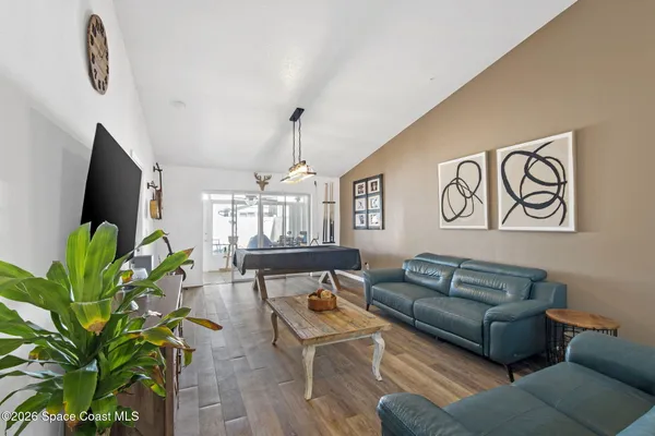 a living room with furniture a potted plant and a flat screen tv