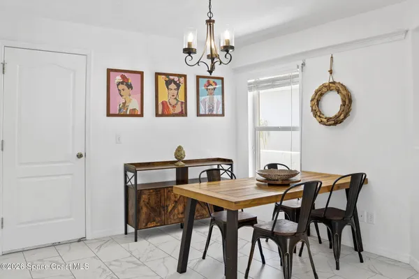 a view of a dining room with furniture and chandelier