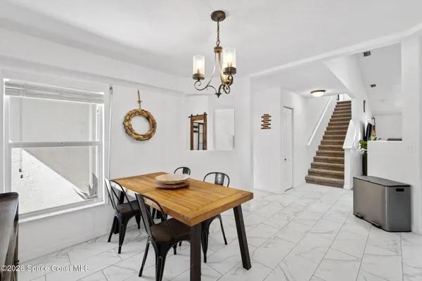 a view of a dining room with furniture and a chandelier