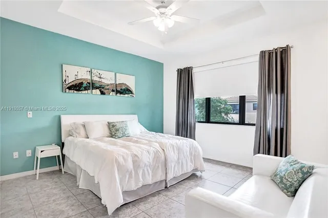 a bedroom with a bed painting and a large window