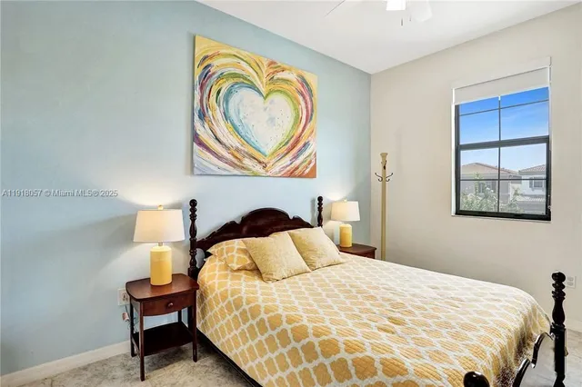 a bedroom with a bed and a lamp on dresser