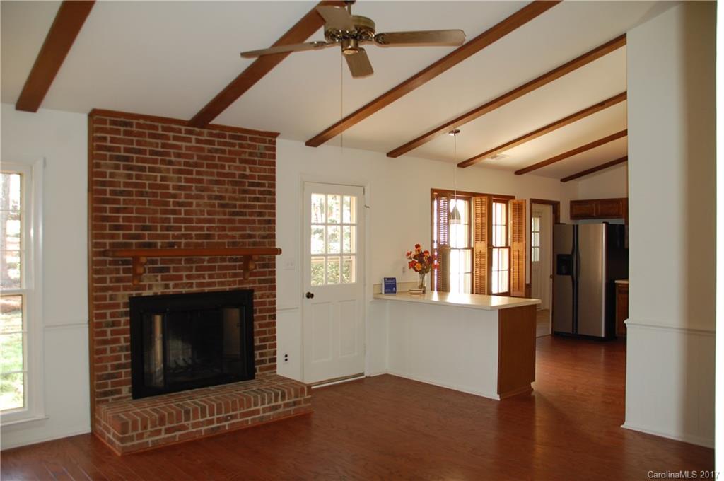 715 Trail Ridge Road Matthews, NC 28105 - Photo 8 of 13 a living room with a fireplace and wooden floor