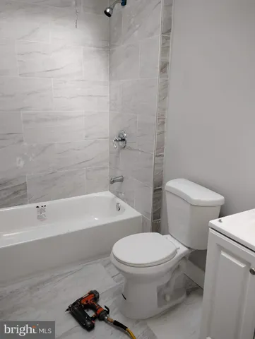 a bathroom with a toilet and a bath tub