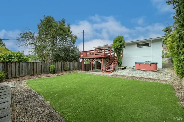 a view of house with backyard and furniture