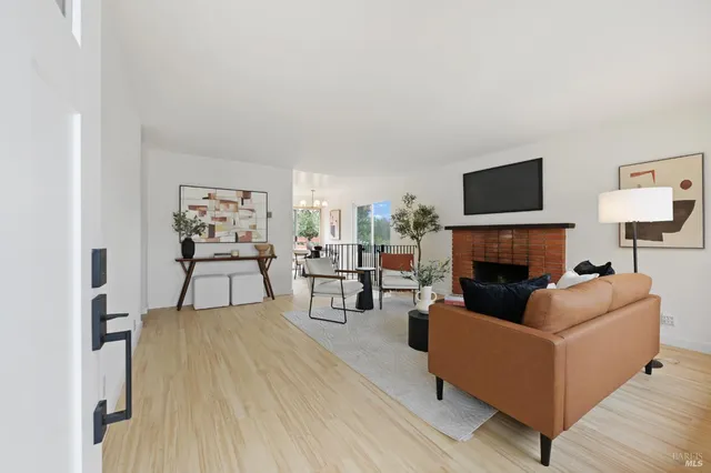 a kitchen with stainless steel appliances kitchen island granite countertop a dining table chairs and a refrigerator