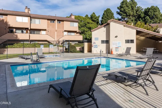 a view of a patio with a table and chairs under an umbrella