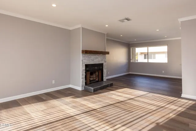 a view of empty room with wooden floor and fireplace