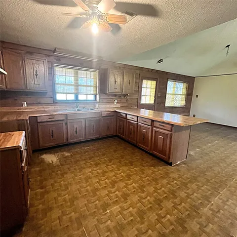 a large kitchen with kitchen island granite countertop a stove sink and cabinets