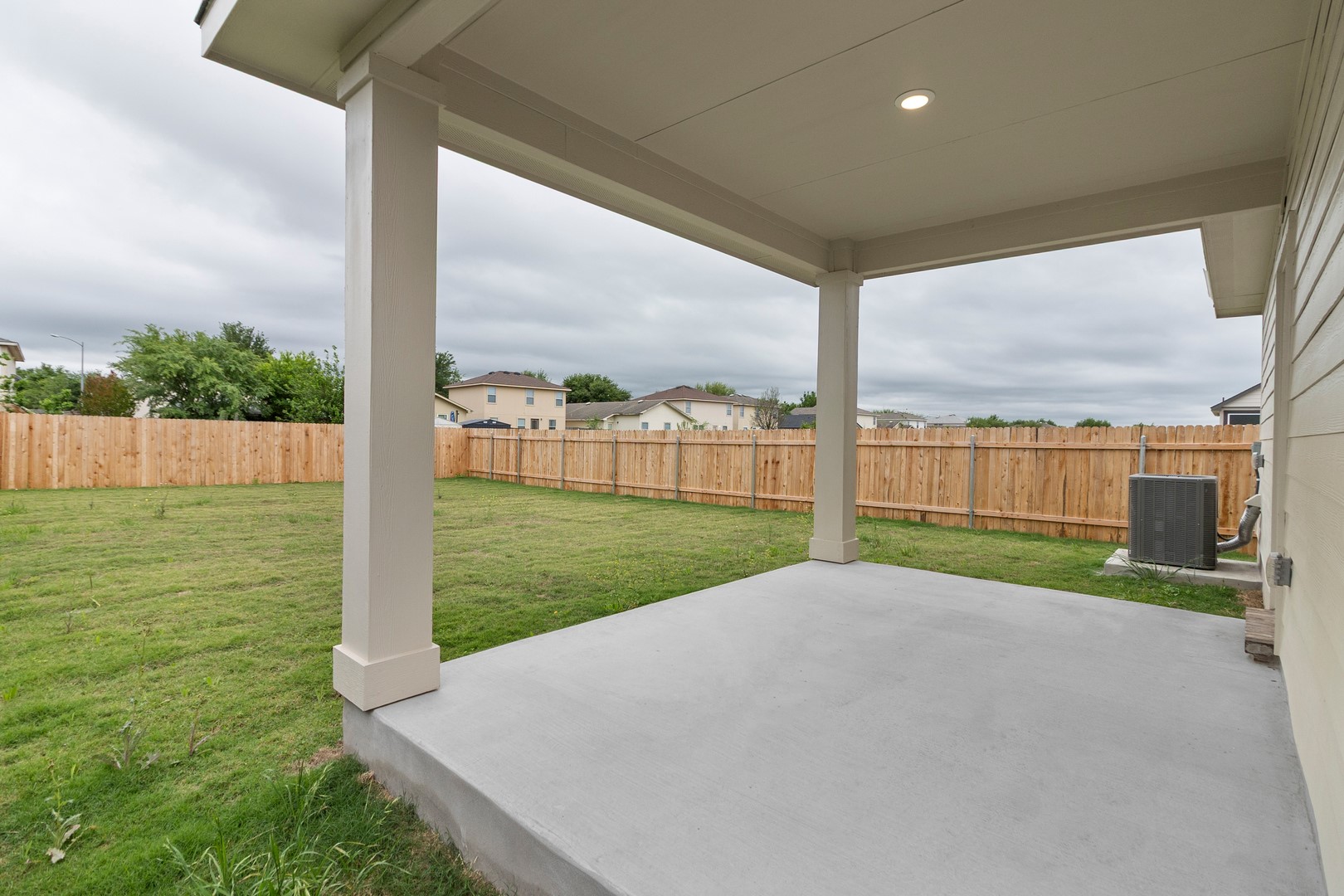 18605 Emu Lane Manor, TX 78653 - Photo 24 of 27 This property features a covered patio with a concrete floor, a spacious fenced yard, and a well-maintained lawn