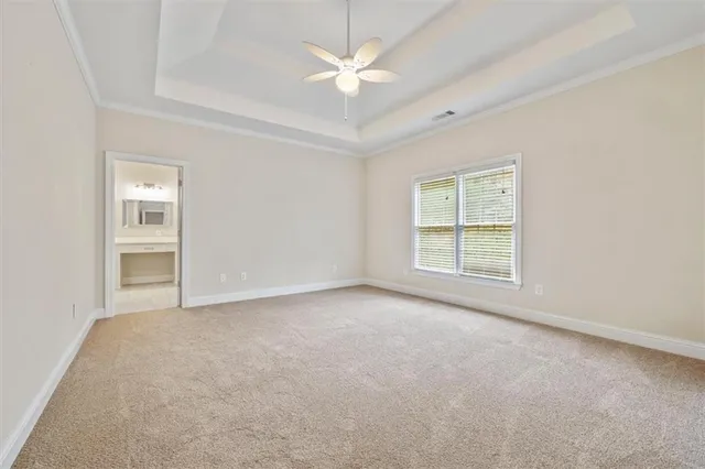 an empty room with windows and ceiling fan