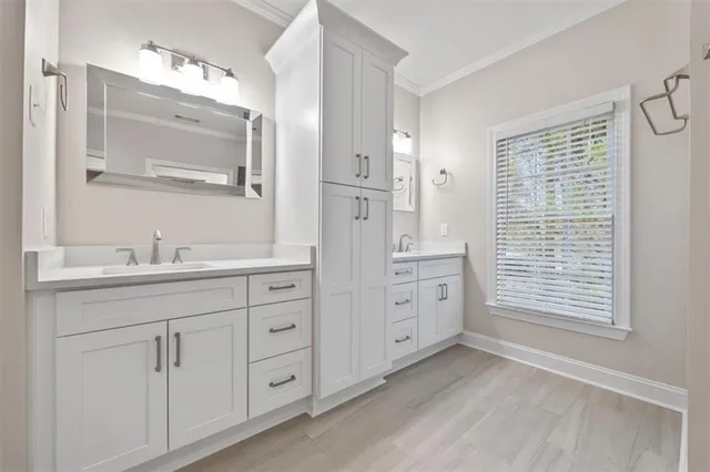 a spacious bathroom with double vanity a mirror a bathtub and a window