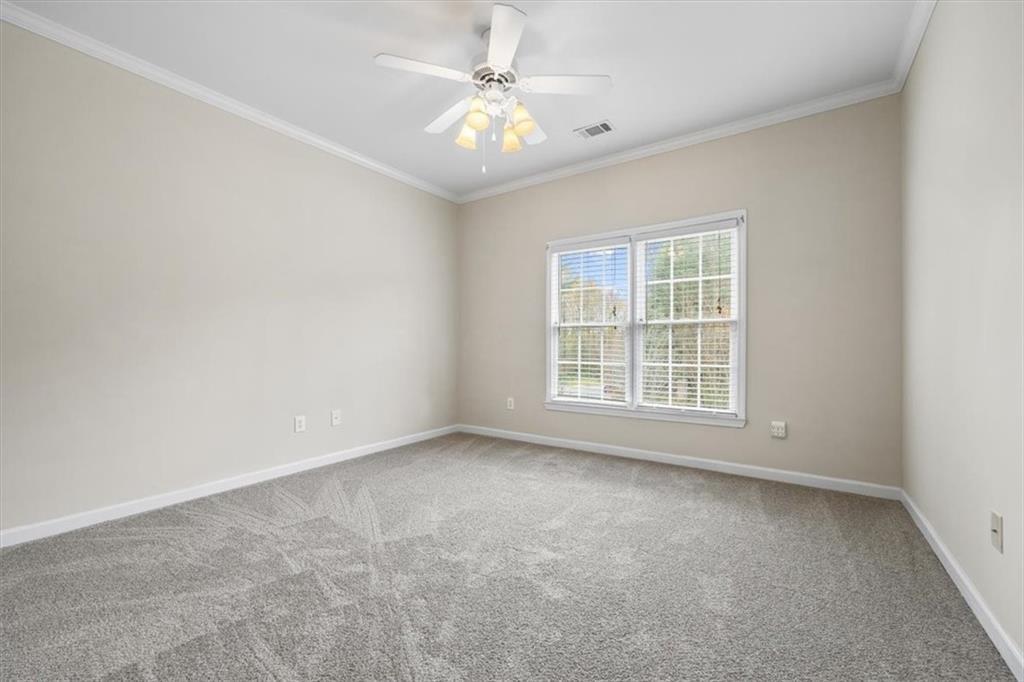 4115 Montvale Crossing Cumming, GA 30041 - Photo 32 of 40 an empty room with chandelier fan and windows