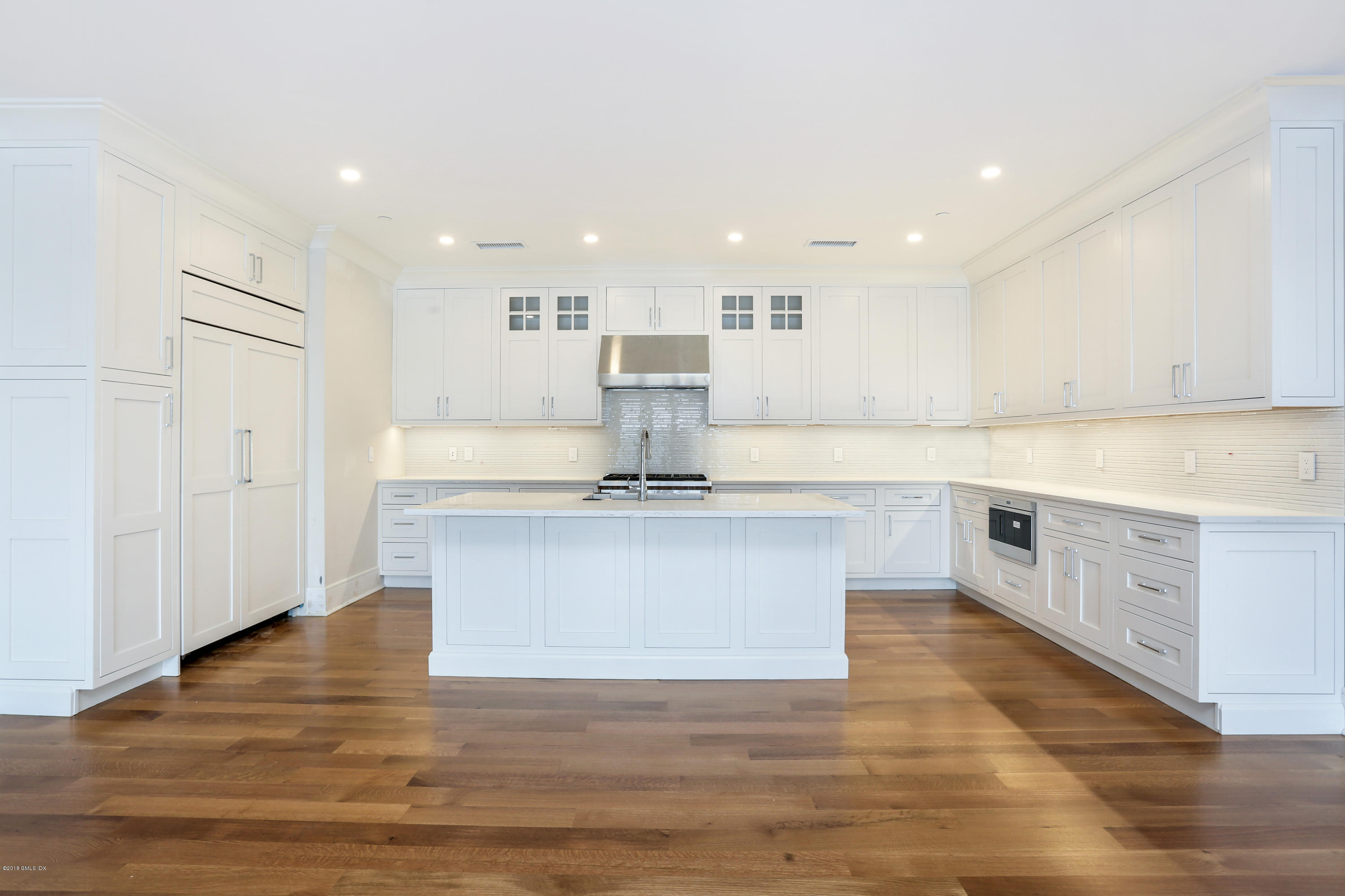 70 Sound View Drive, Unit 2 WEST Greenwich, CT 06830 - Photo 3 of 12 a large kitchen with kitchen island a sink a stove and white cabinets