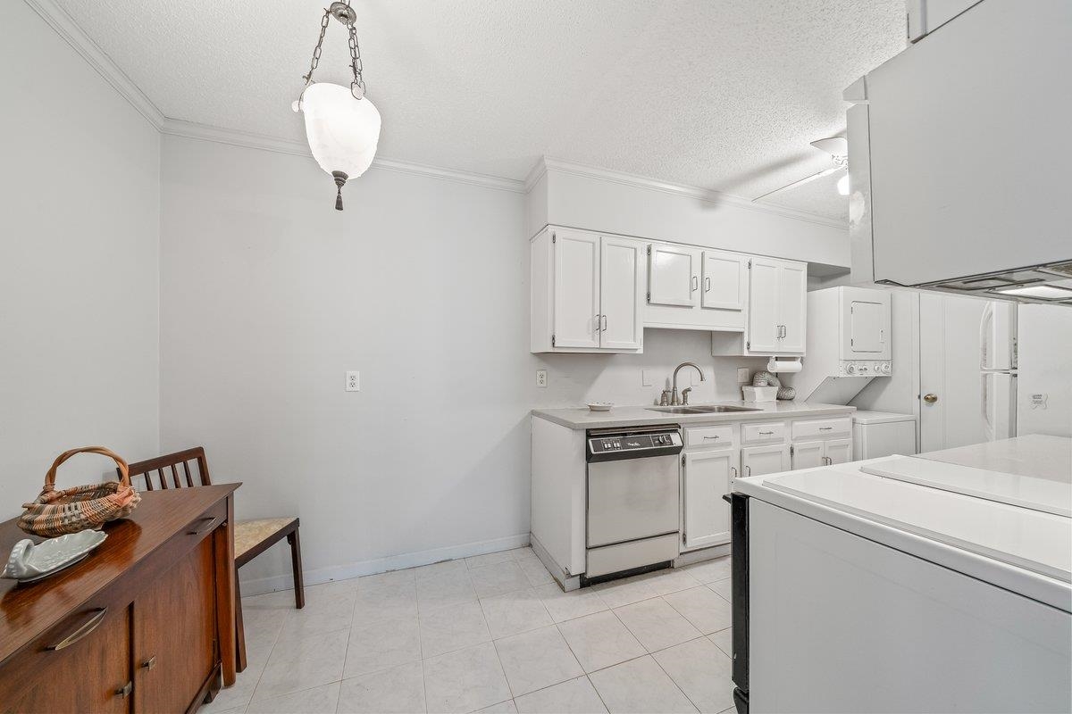 3080 Walnut Grove Road, Unit 507 Memphis, TN 38111 - Photo 14 of 27 Kitchen with light countertops, ornamental molding, white cabinetry, white dishwasher, and a textured ceiling