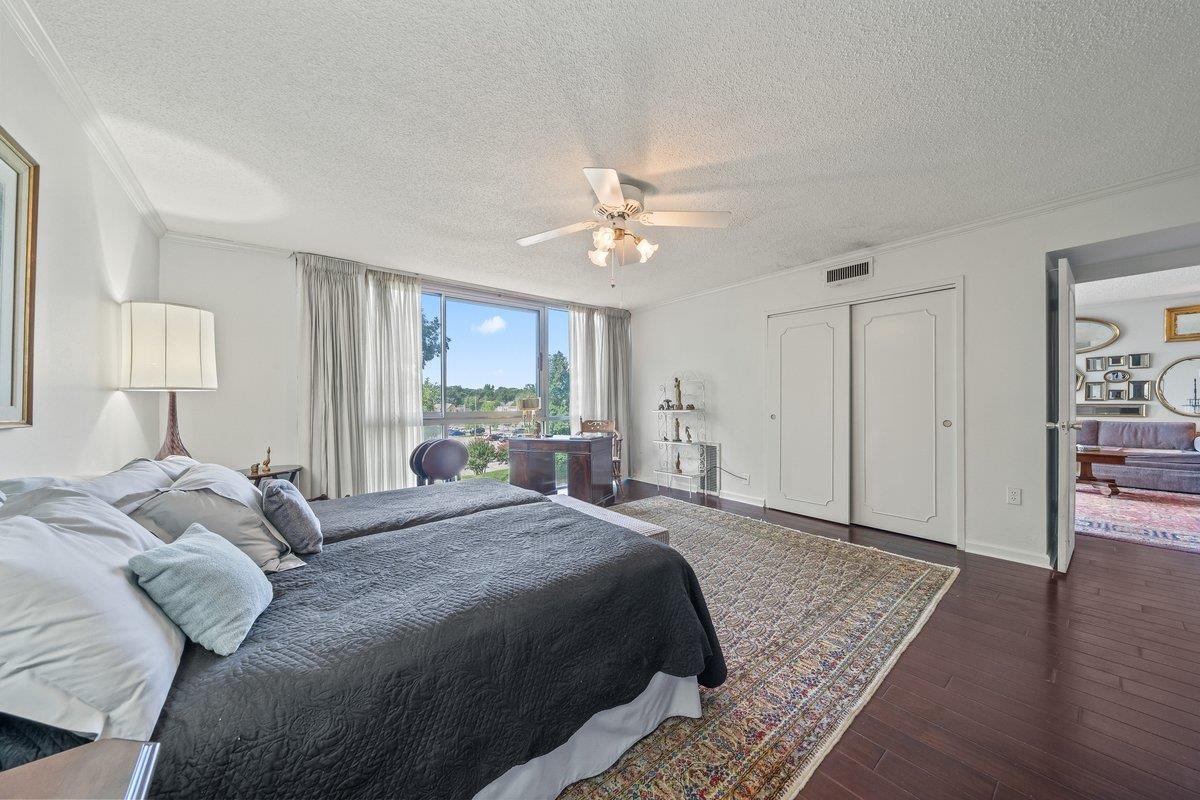 3080 Walnut Grove Road, Unit 507 Memphis, TN 38111 - Photo 18 of 27 Bedroom featuring a textured ceiling, crown molding, wood finished floors, ceiling fan, and a closet