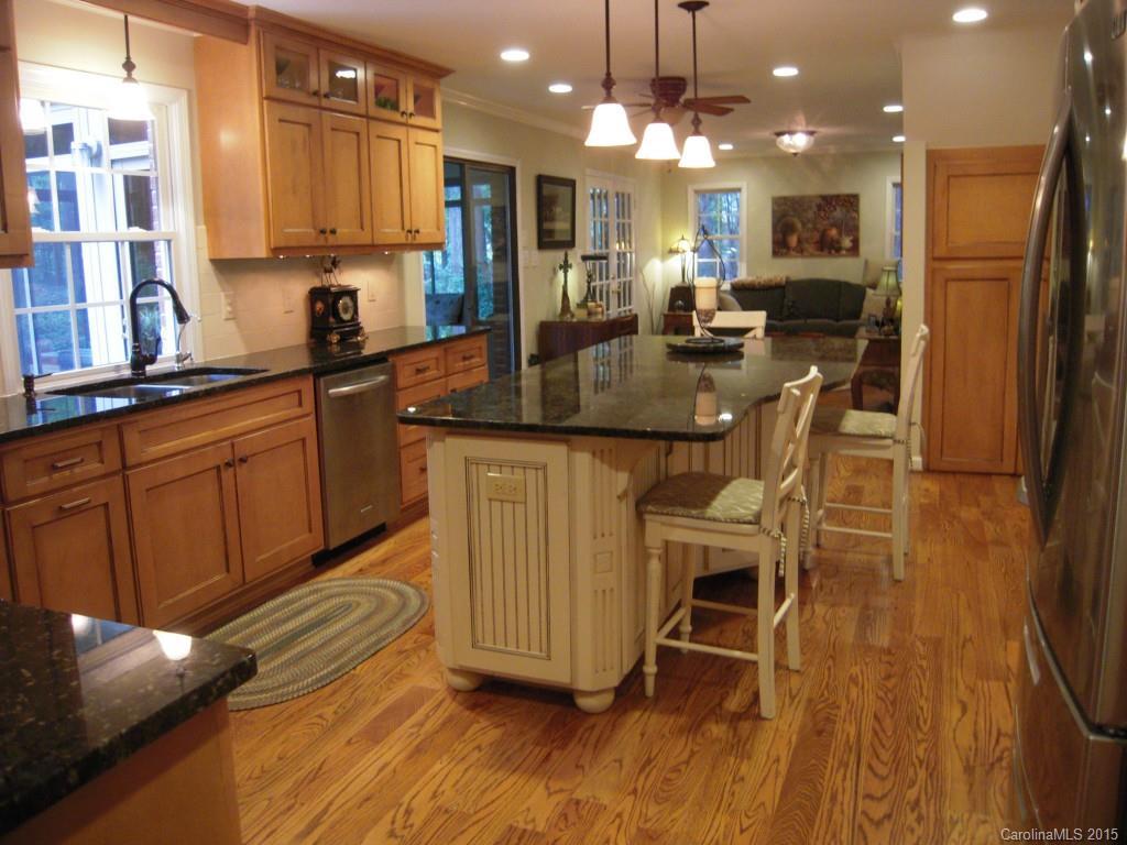 3226 Gray Moss Road Charlotte, NC 28270 - Photo 10 of 24 a kitchen with stainless steel appliances granite countertop a stove top oven a sink dishwasher a dining table and chairs with wooden floor