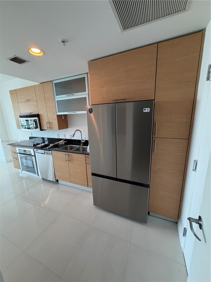 60 Southwest 13th Street, Unit 1605 Miami, FL 33130 - Photo 4 of 18 a kitchen with stainless steel appliances a refrigerator and a cabinets