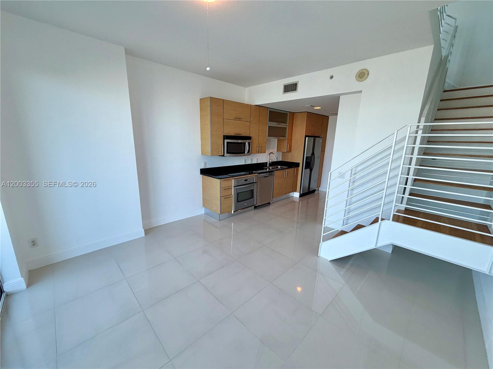 60 Southwest 13th Street, Unit 1605 Miami, FL 33130 - Photo 10 of 18 a living room with stainless steel appliances furniture a rug and a window