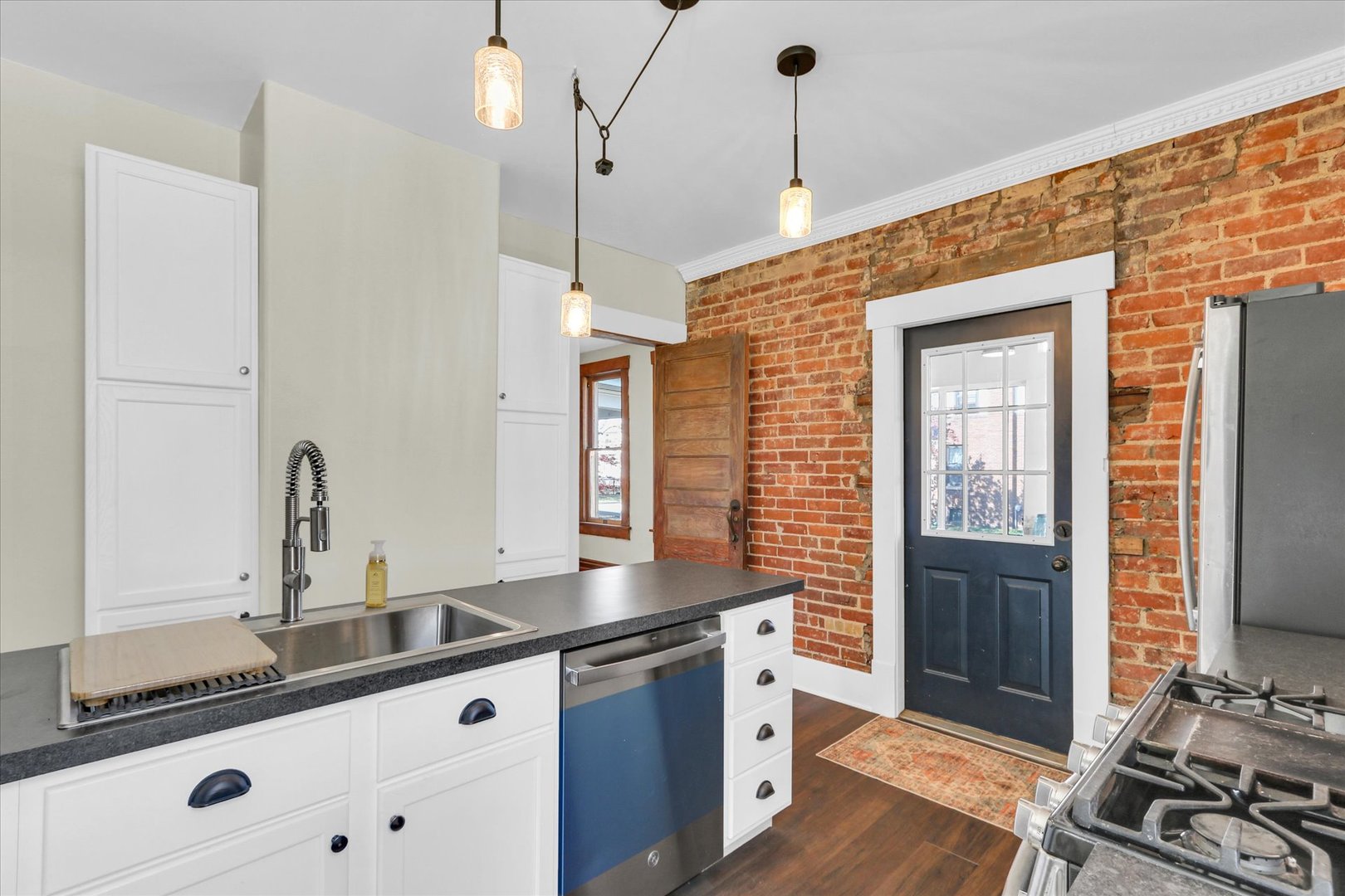1120 West Church Street Champaign, IL 61821 - Photo 17 of 49 a kitchen with granite countertop a sink stove and cabinets