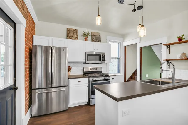 a kitchen with stainless steel appliances granite countertop a refrigerator a stove a sink and a refrigerator