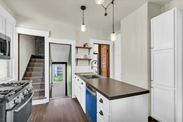 a kitchen with kitchen island white cabinets and stainless steel appliances