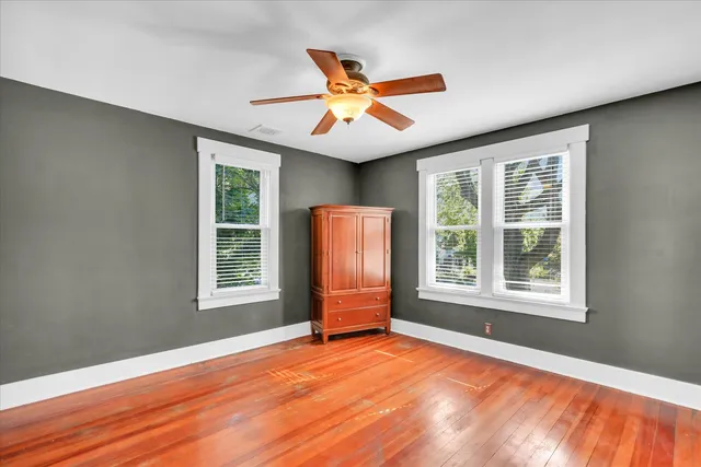 an empty room with a window and ceiling fan