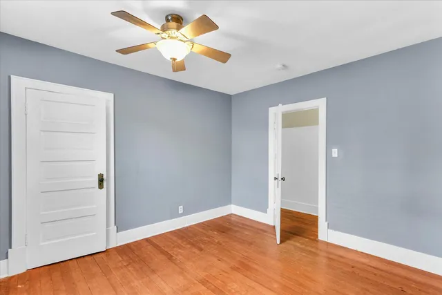 an empty room with closet and fan