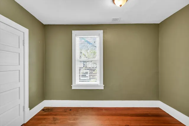 a view of a room with wooden floor and a window