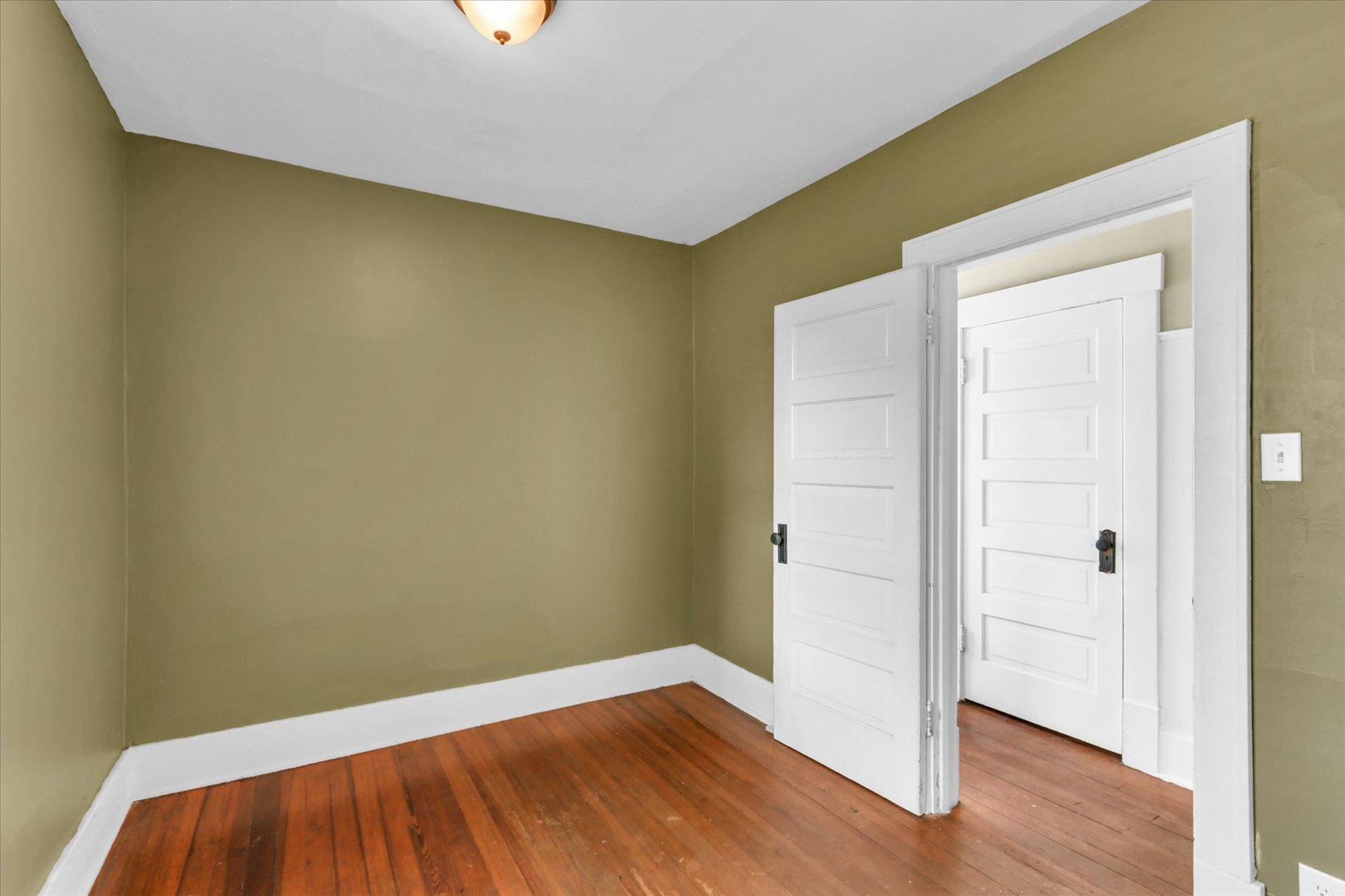 1120 West Church Street Champaign, IL 61821 - Photo 34 of 48 an empty room with wooden floor and closet