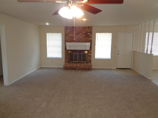 29419 Raestone Street Spring, TX 77386 - Photo 2 of 19 an empty room with a fireplace and windows