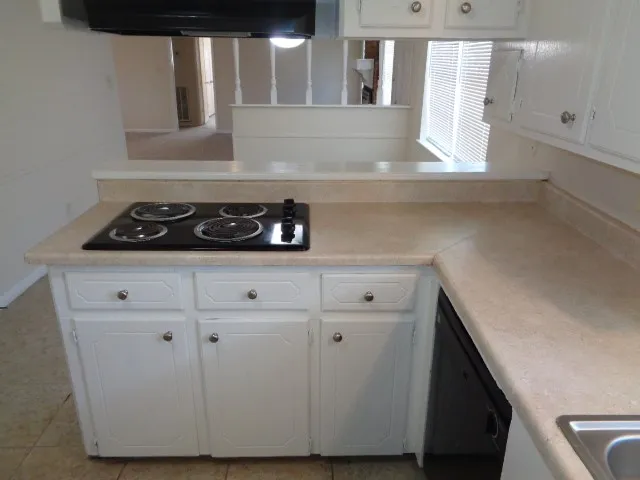 a kitchen with a stove and a white cabinet