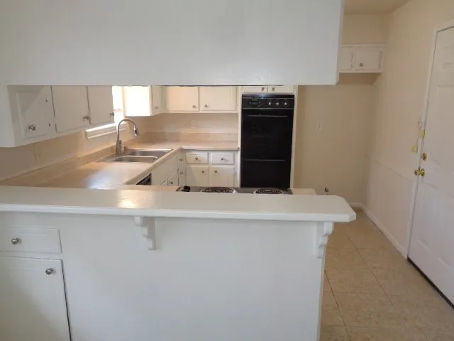 a view of cabinets with stainless steel appliances wooden floor