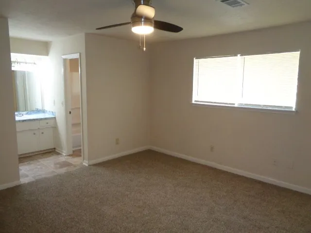 en empty room with windows and chandelier fan