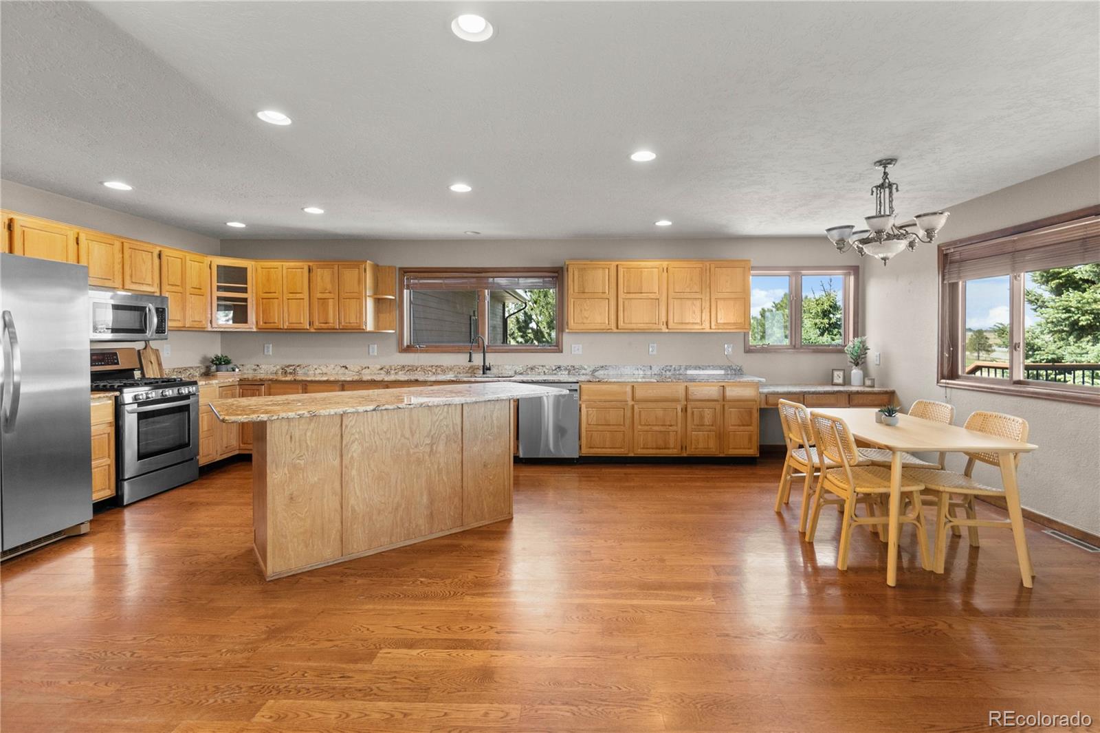 74 Rocky Cliff Road Elizabeth, CO 80107 - Photo 11 of 50 a kitchen with stainless steel appliances granite countertop wooden cabinets a stove a sink a dining table and chairs
