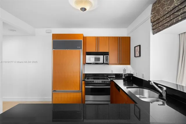 a kitchen with stainless steel appliances granite countertop a sink stove and refrigerator
