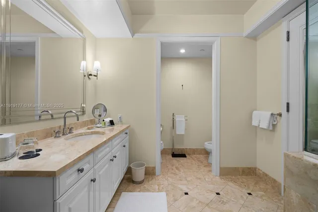 a spacious bathroom with a granite countertop toilet a sink and a mirror